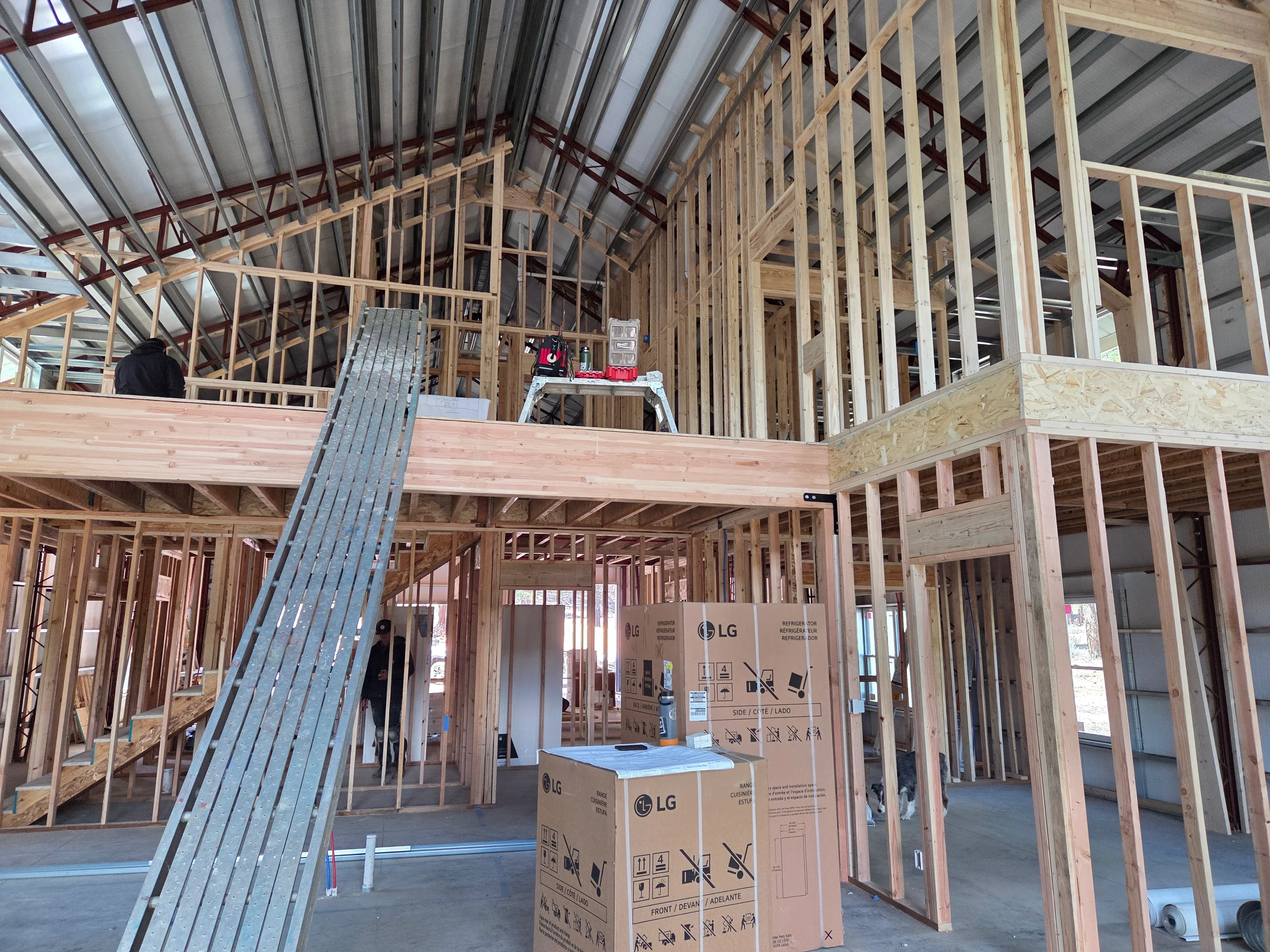 Two-story wood frame construction with metal roof trusses, interior walls, and metal staircase